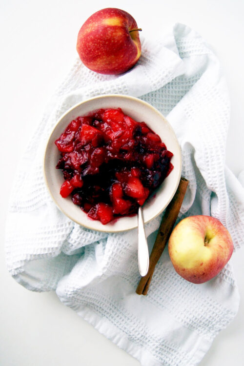 Cranberry sauce in a bowl with apples.
