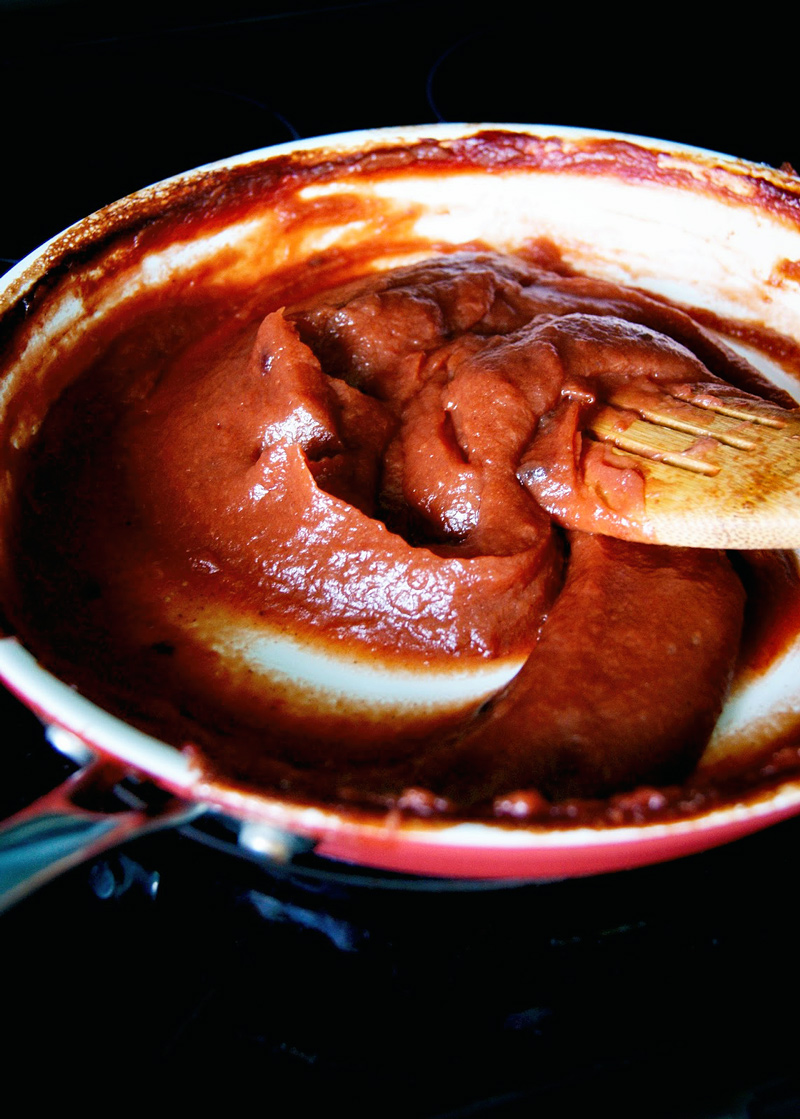 Apple butter in a large pan, thick and a dark red colour.