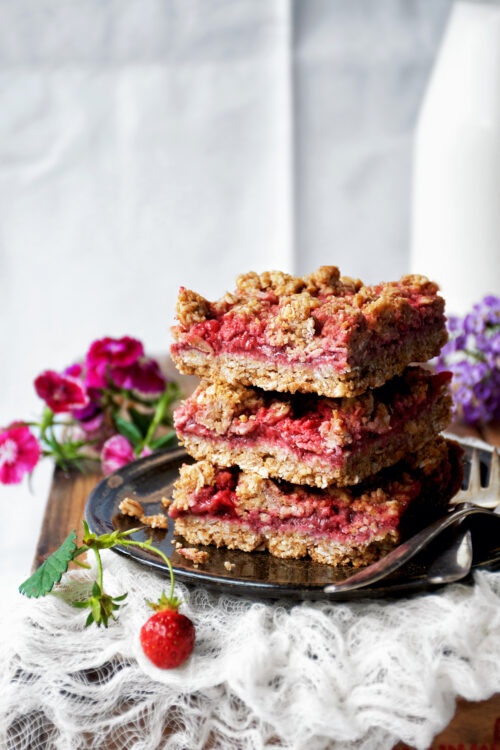 A stack of three crumble bars with flowers around.