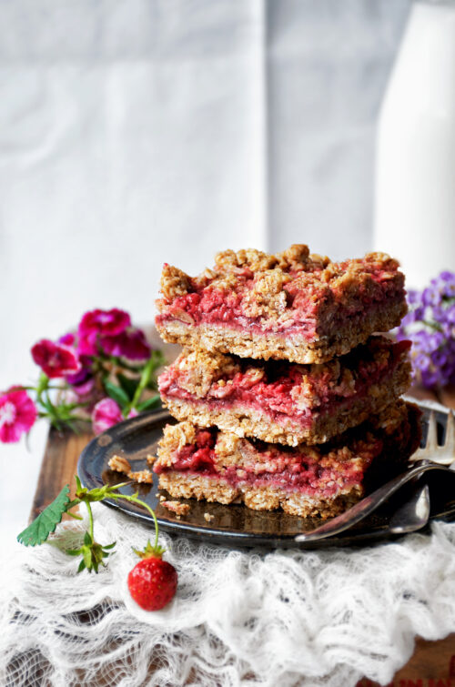 A stack of three crumble bars with flowers around.