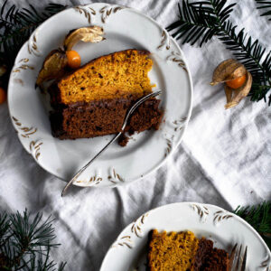 Slices of layer cake on small plates, top down view.