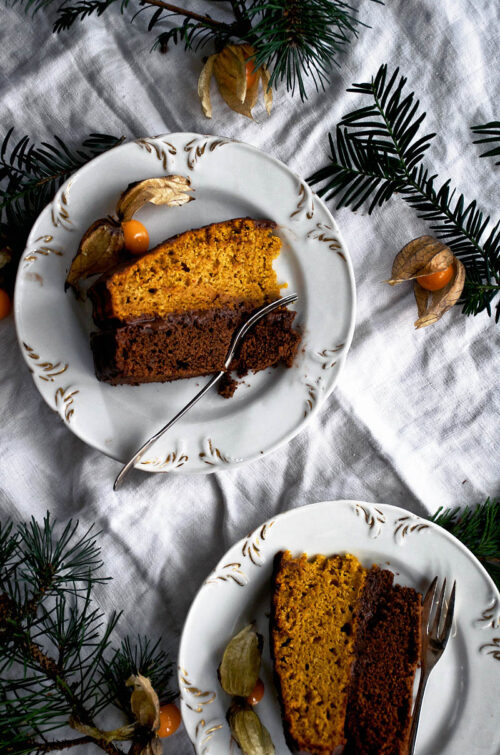 Slices of layer cake on small plates, top down view.