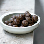 A bowl of date balls on a window ledge.
