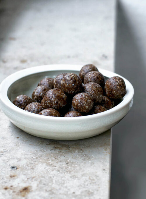 A bowl of date balls on a window ledge.