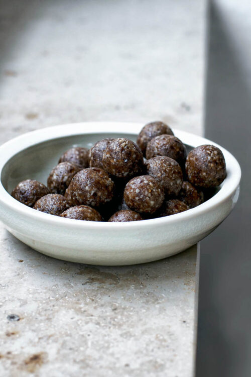 A bowl of date balls on a window ledge.