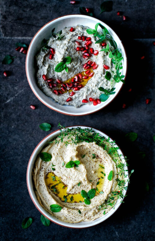 Two bowls, top down view, one with baba ghanoush and the other with hummus.