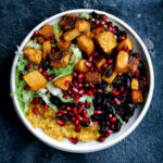 A rice bowl with winter squash, cabbage, and beans, top down view.