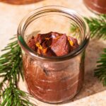 Chocolate mousse in small glass jars topped with orange zest.