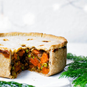 Hot water crust pie with vegetable filling, slice removed to show interior.