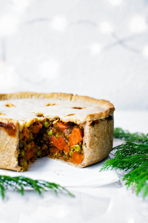 Hot water crust pie with vegetable filling, slice removed to show interior.