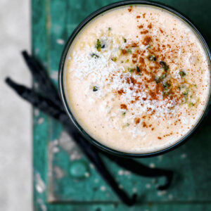 Top down view of a light orange smoothie in a glass.