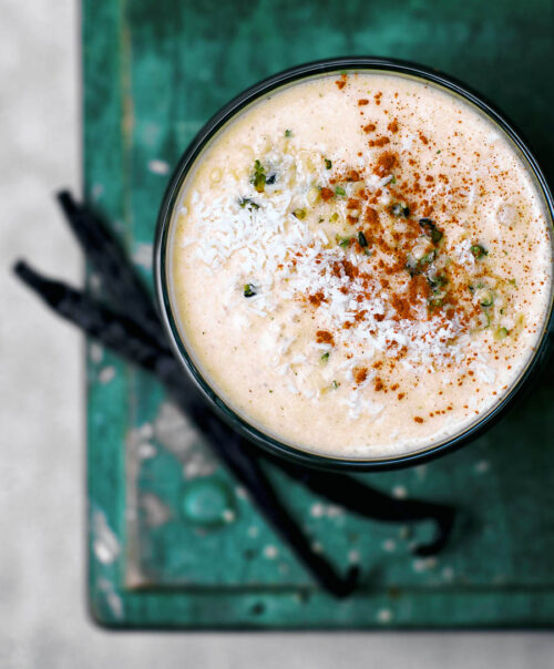 Top down view of a light orange smoothie in a glass.