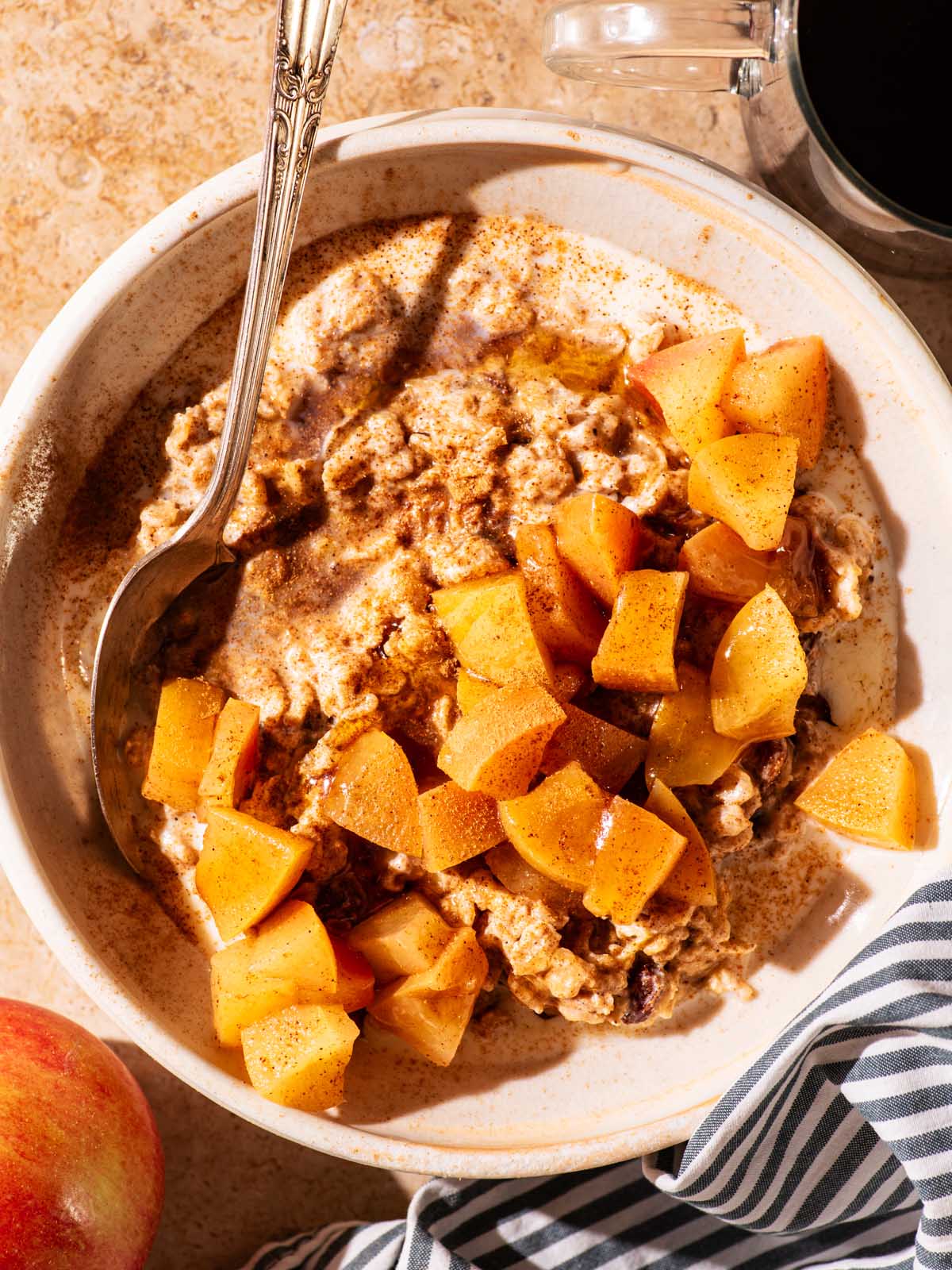 A bowl of porridge topped with cooked apple pieces.