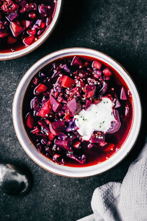 A bowl of red beet soup topped with yogurt.