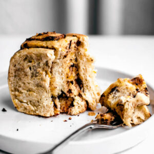 A chocolate and orange filled sweet roll on a small plate with a fork.