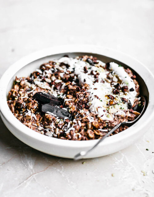 Chocolate overnight oats in a shallow bowl with extra yogurt.