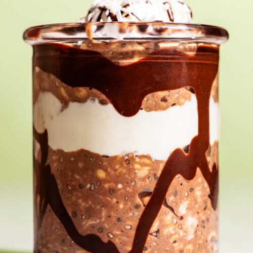 Chocolate overnight oats layered in a jar with yogurt and melted chocolate.