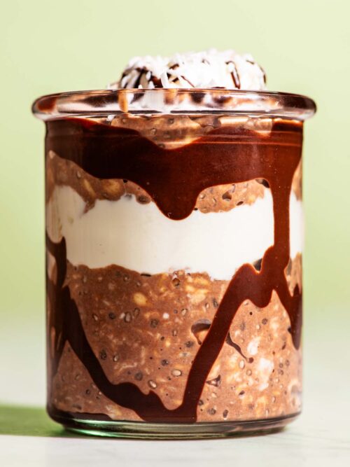 Chocolate overnight oats layered in a jar with yogurt and melted chocolate.