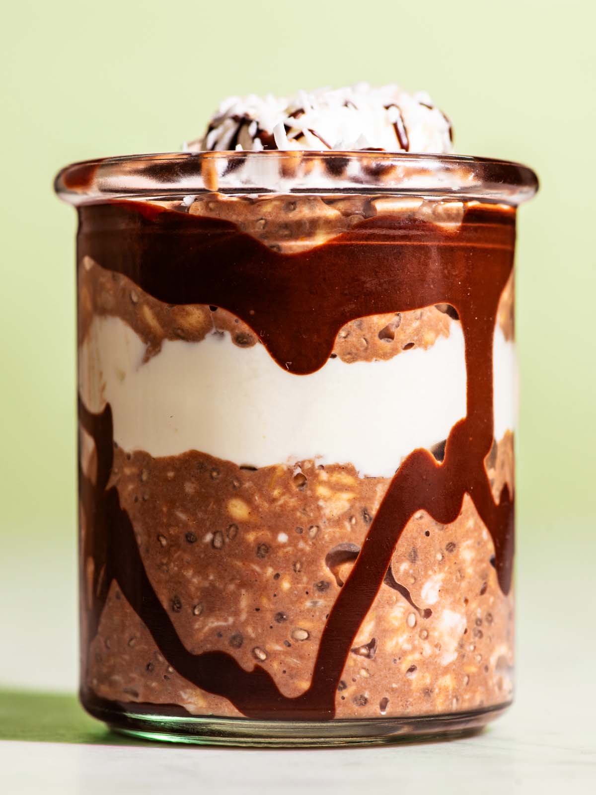 Chocolate overnight oats layered in a jar with yogurt and melted chocolate.