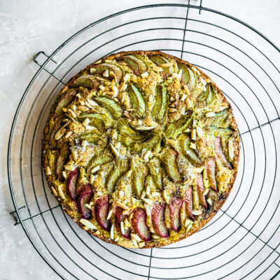 Rhubarb topped cake on a large round metal cooling rack.