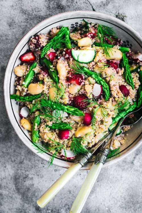 Strawberry, radish, cucumber, and asparagus quinoa salad in large bowl.