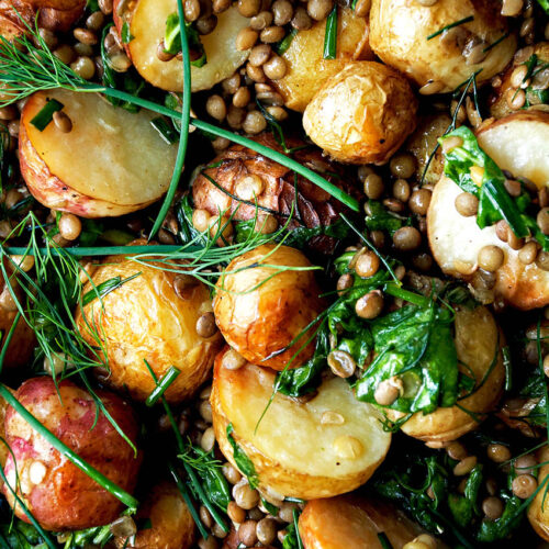Close up of roasted potato salad with lentils and herbs.