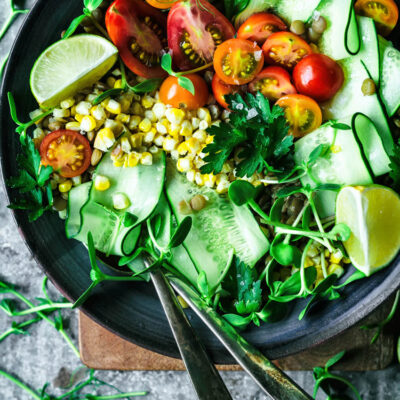 Salad with cucumber, corn, cherry tomatoes, and lime.