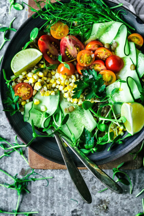 Salad with cucumber, corn, cherry tomatoes, and lime.