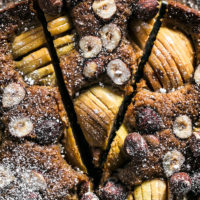 Apple hazelnut cake on dark wooden surface.