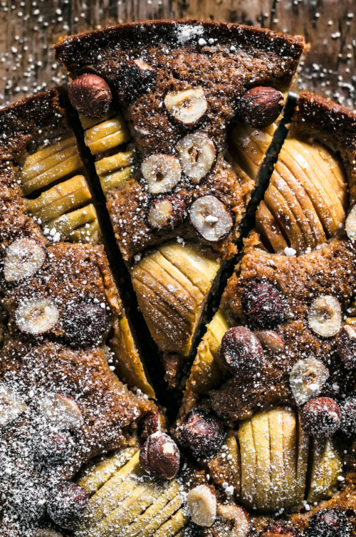 Apple hazelnut cake on dark wooden surface.