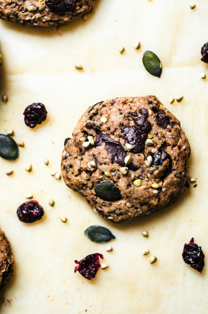 Buckwheat cookies with dried fruit and chocolate on parchment paper.