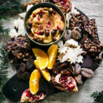 Cookie dough dip in a bowl on a platter with cookies and fruit.