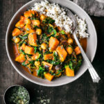 A bowl of sweet potato curry with rice in the bowl.