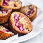 Rhubarb muffins on a paper lined plate, front view.