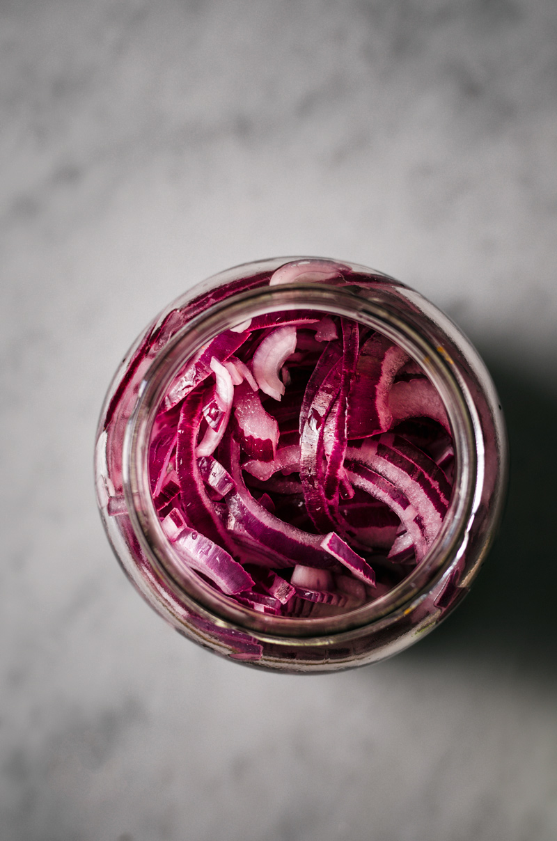 A jar of red onions for pickling, before they're fully pickled.