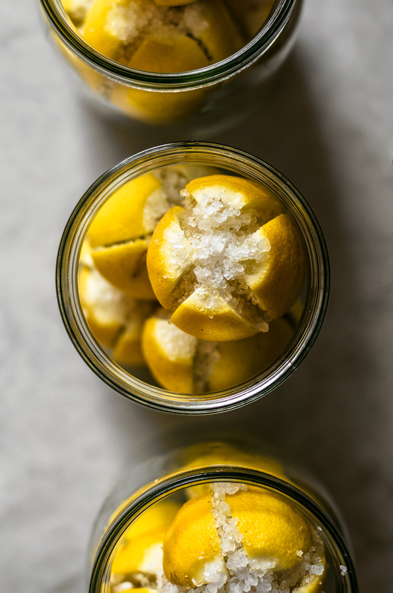 Preserved lemons stuffed with coarse salt in jars.