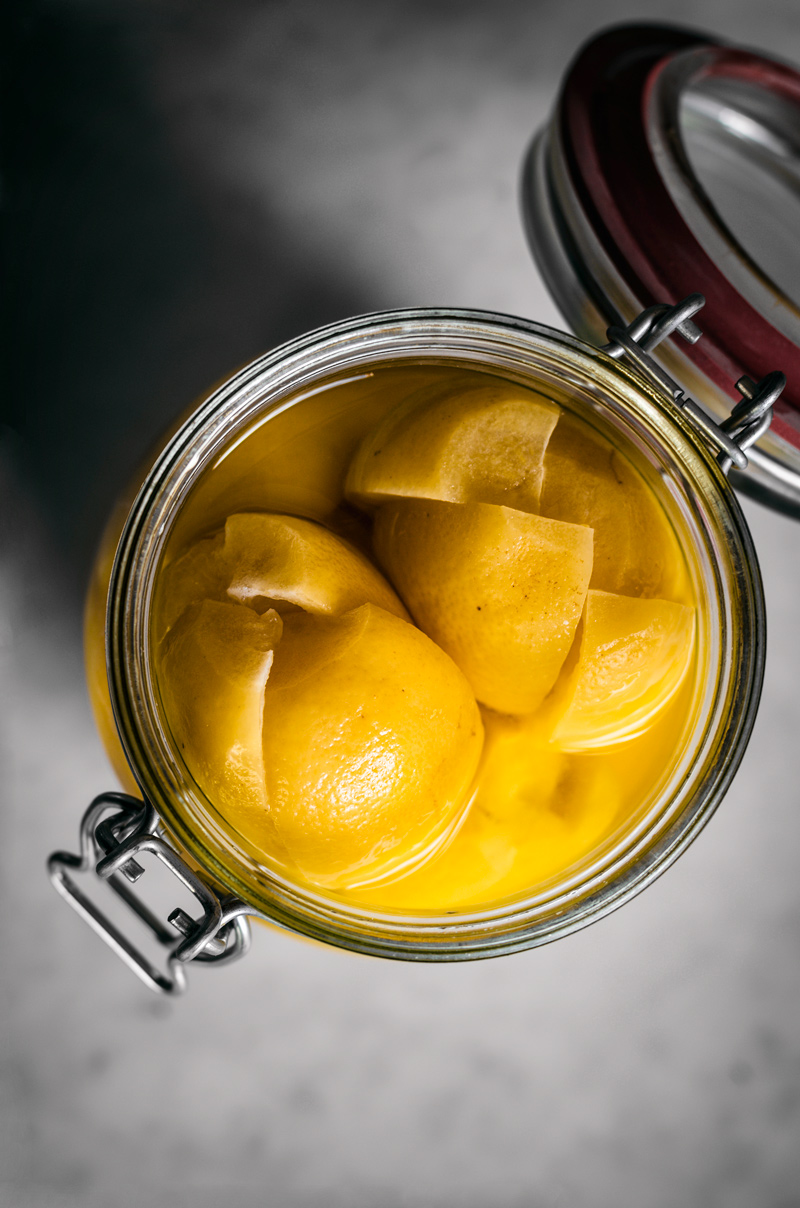Preserved lemons in a flip top jar, lid open.