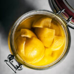 Top down view of a glass jar filled with preserved lemons.