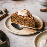A slice of apple crumble cake with yogurt on top.