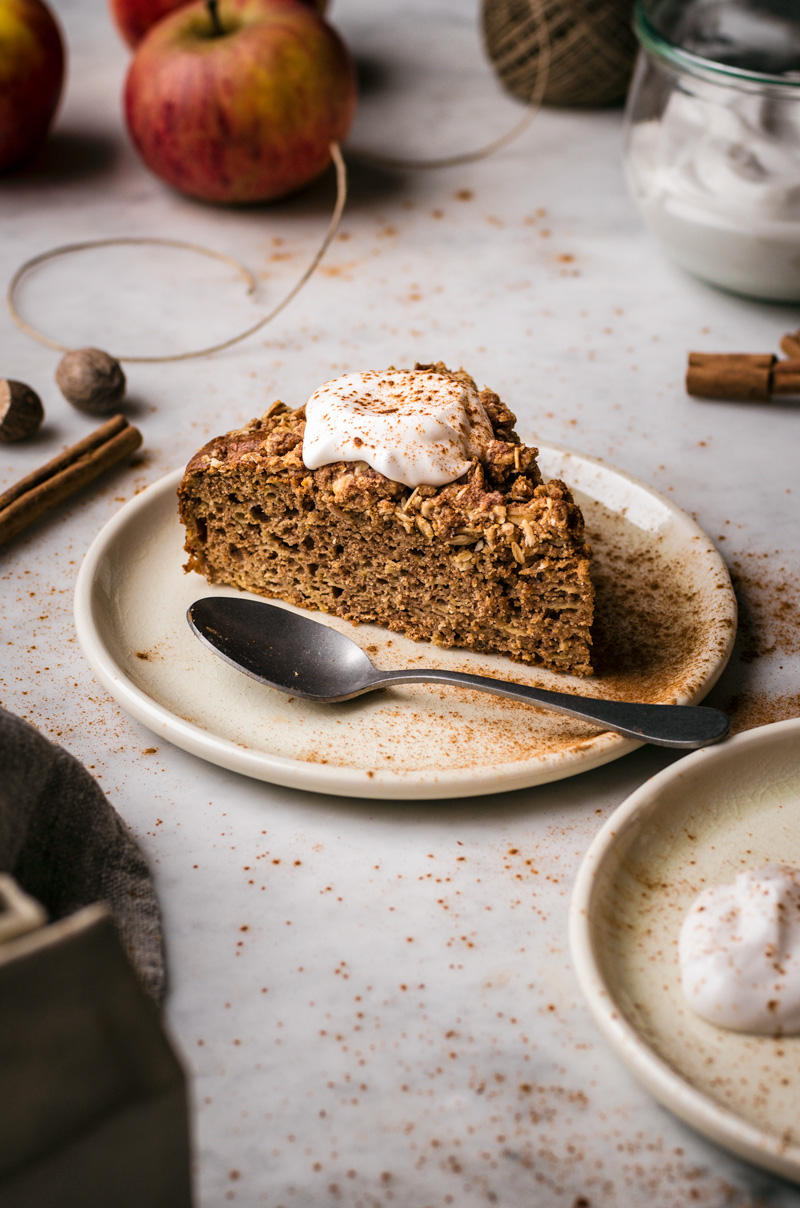 A slice of apple crumble cake with yogurt on top.