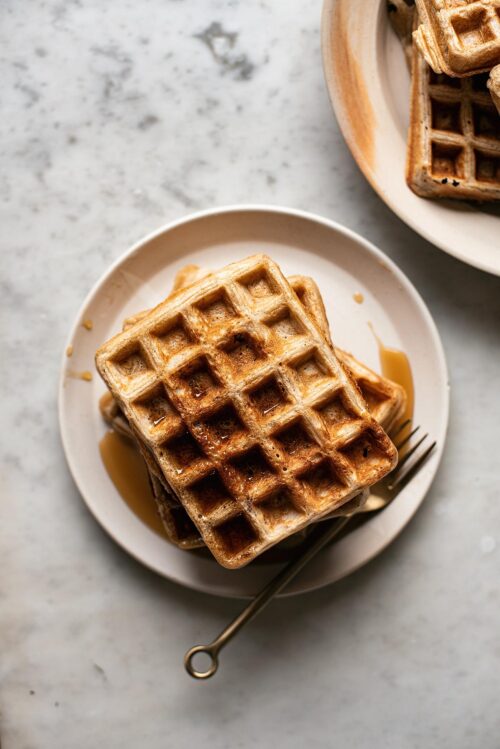 Stack of waffles with maple syrup, top down view.