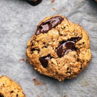 Multigrain chocolate chunk cookies on parchment paper, close up.