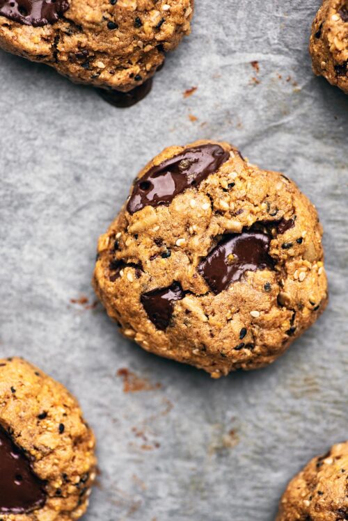 Multigrain chocolate chunk cookies on parchment paper, close up.