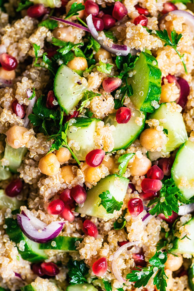 Close up of chickpea quinoa salad with cucumber, red onion, and pomegranate.