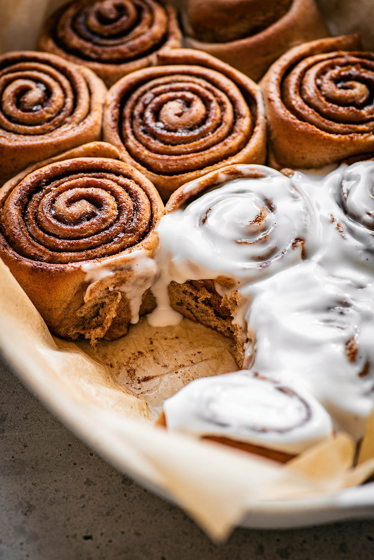 Close up of cinnamon rolls with icing melting down.