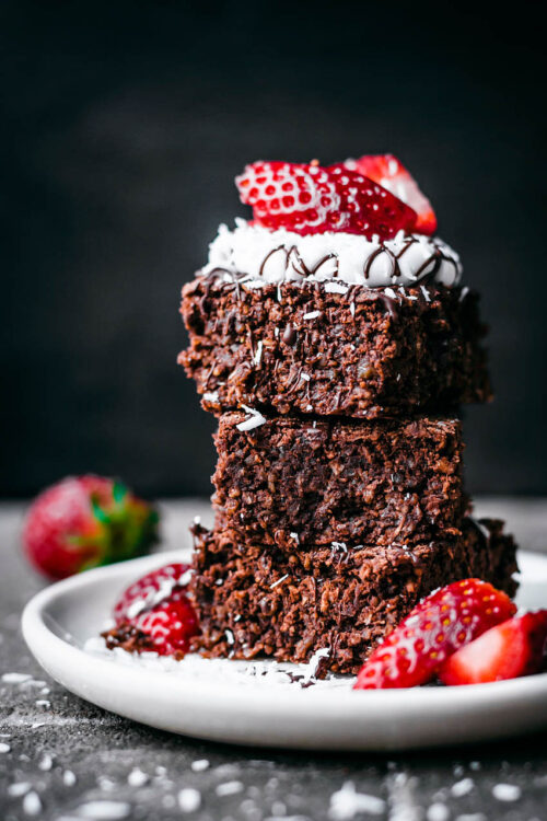 A stack of breakfast brownies with yogurt and strawberries.