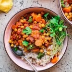 Bowls of chickpea stew with rice on a stone background.
