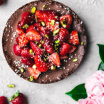 Chocolate coconut pie topped with strawberries and pistachios.