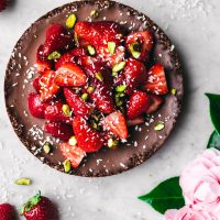 Chocolate coconut pie topped with strawberries and pistachios.