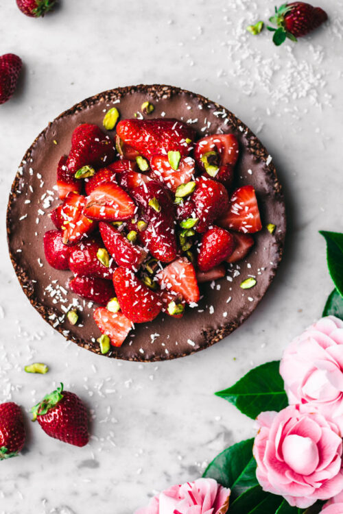 Chocolate coconut pie topped with strawberries and pistachios.